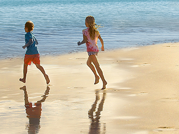 ילדים רצים בחוף ים של מלון